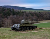 Historical photo of a classic American tank rolling through rugged terrain.