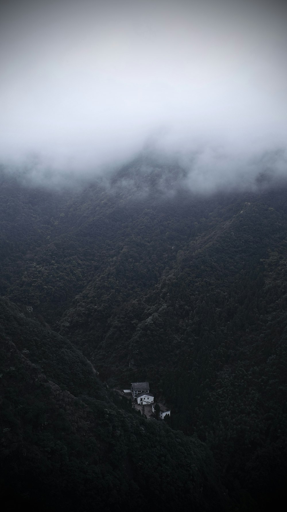 an aerial view of a house in the middle of a mountain