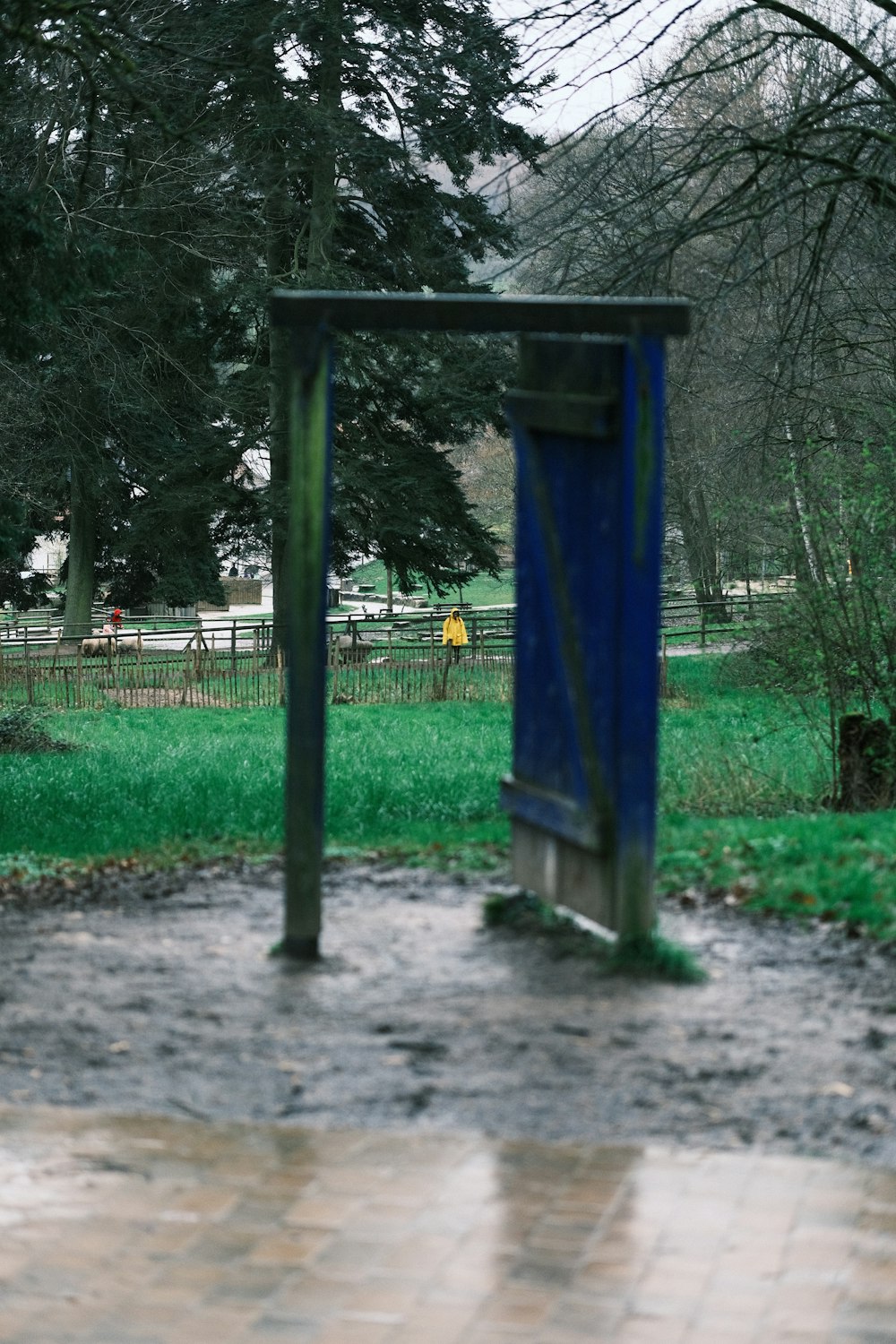 uma porta azul aberta no meio de um parque