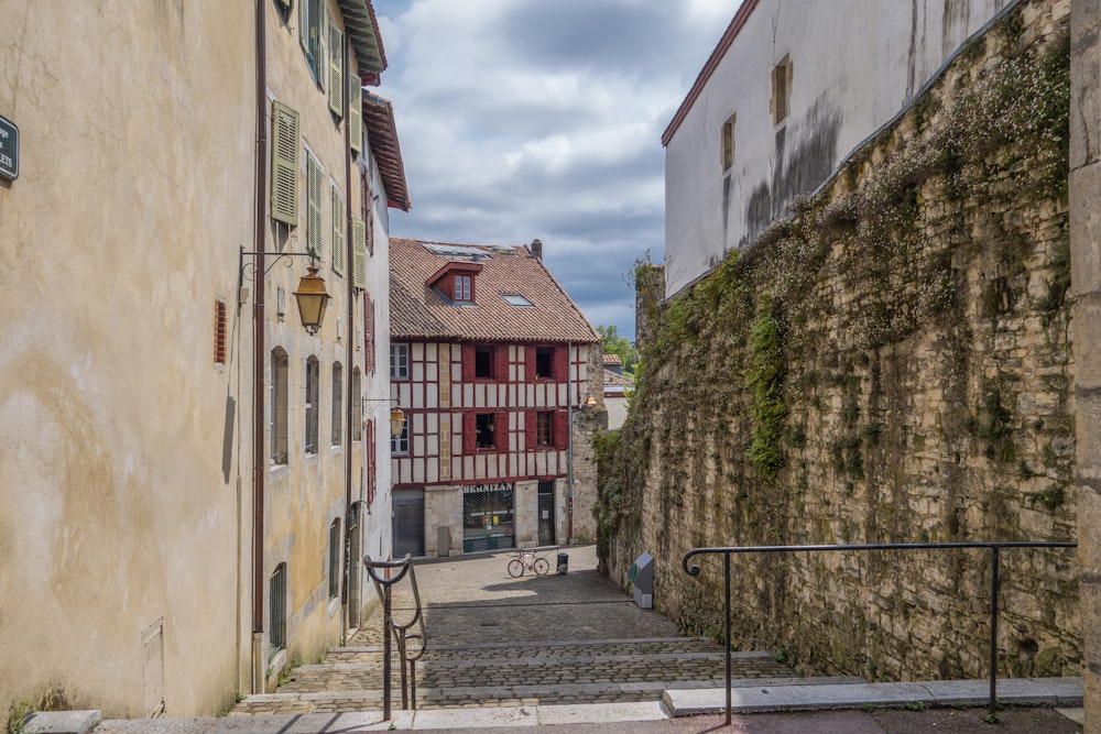 uma rua estreita com uma parede de pedra e escadas