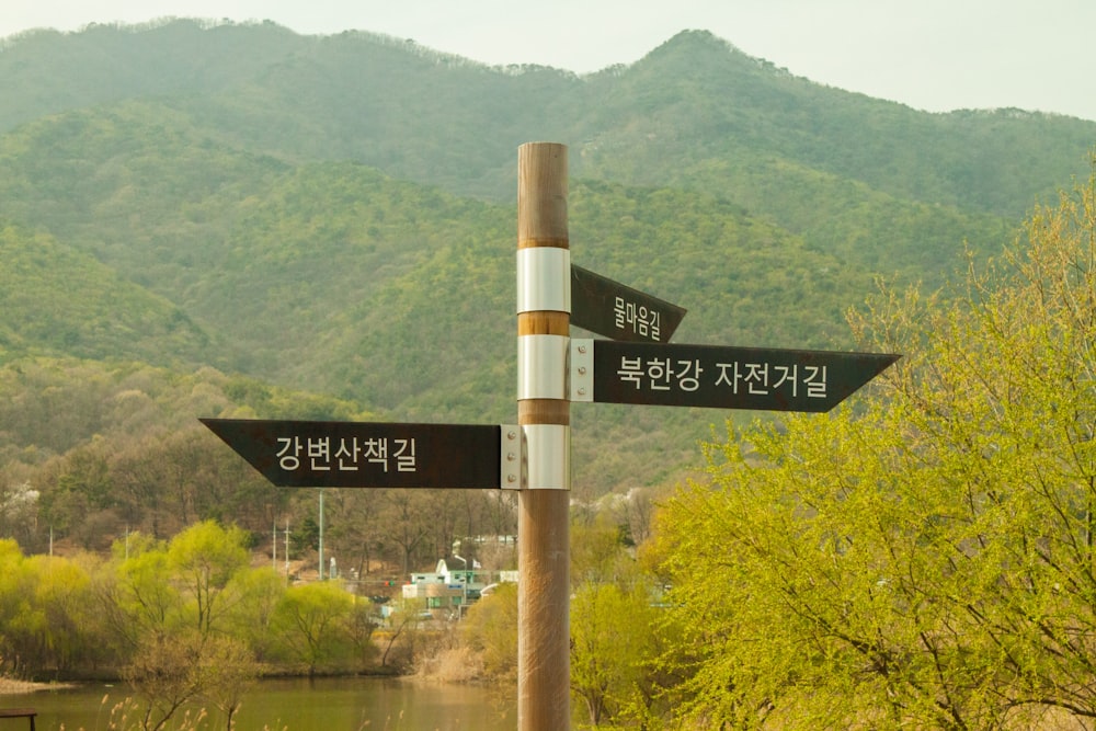 a wooden pole with two black and white signs on it