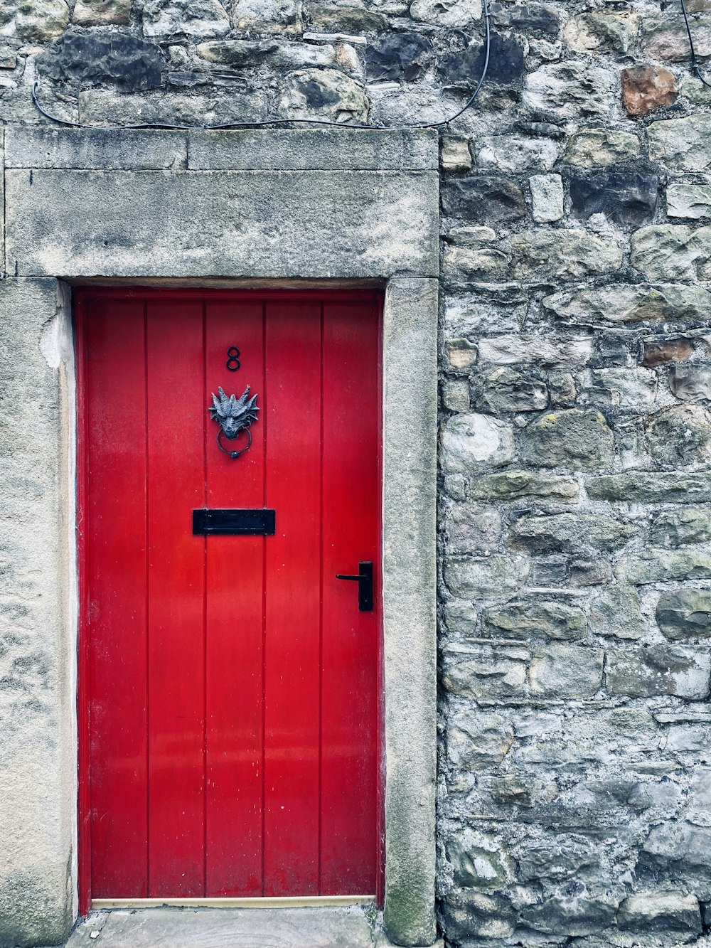 a red door is in a stone building