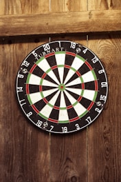 A vibrant dartboard setup in a cozy club environment with players engaged in a friendly game.
