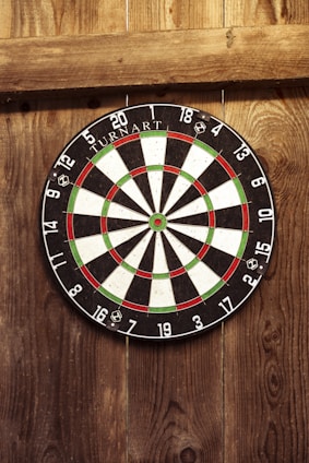 A lively dartboard with players aiming, set against a backdrop of Wyoming's rugged landscape.