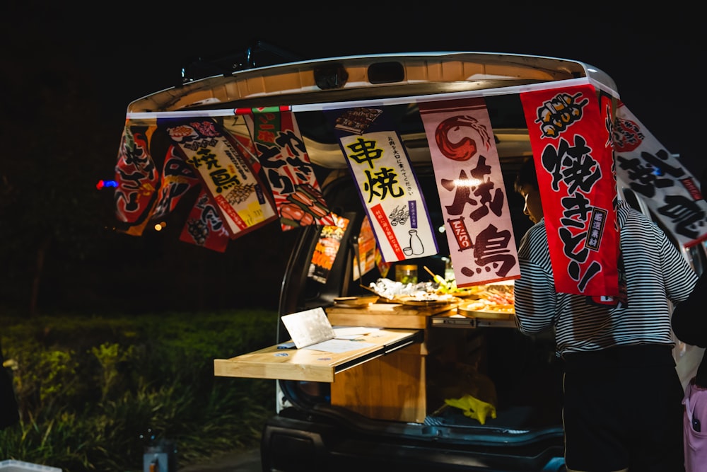 a food cart with a bunch of banners hanging from it's roof