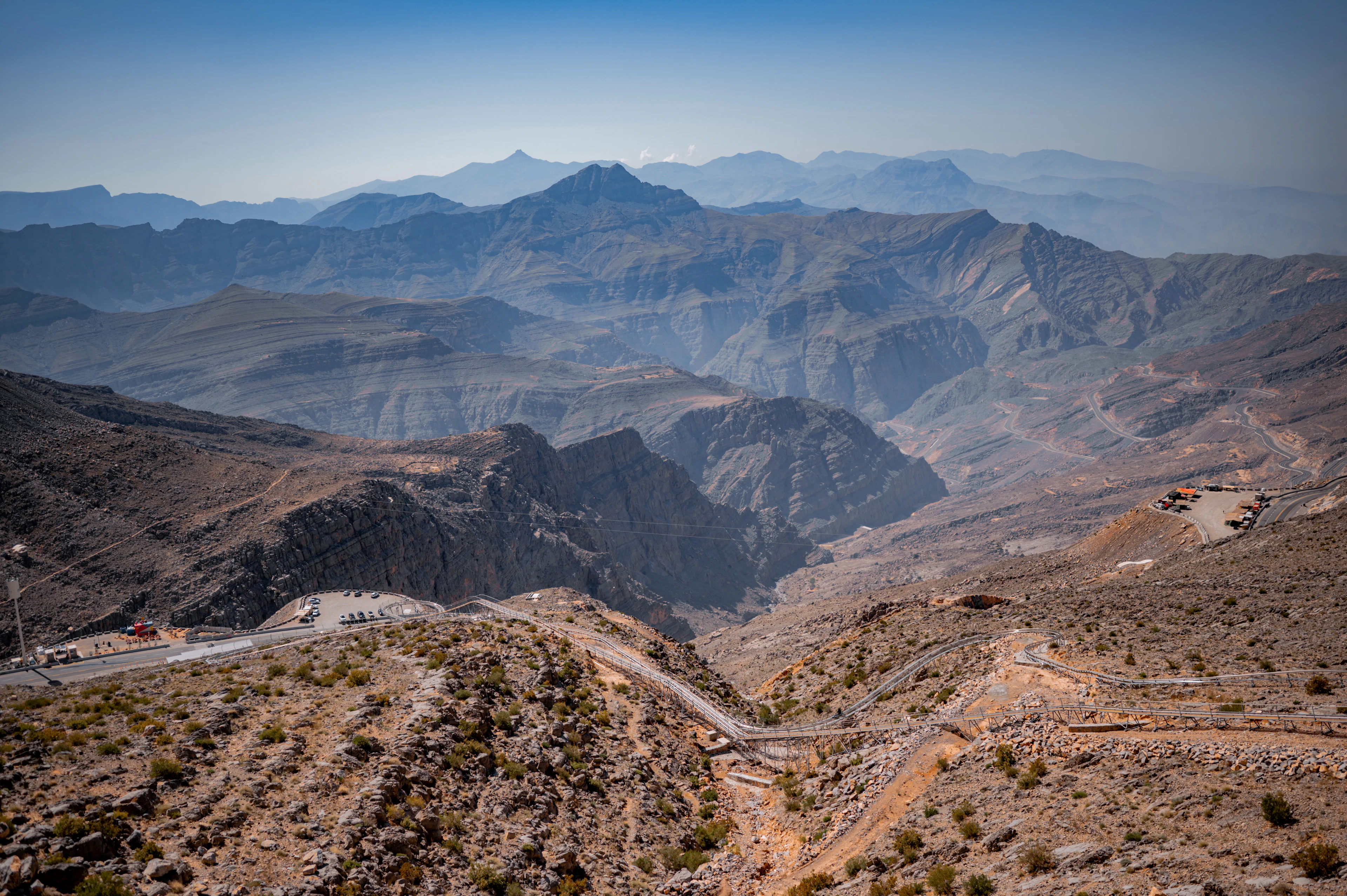 A winding road and mountain ridges to the horizon, seen from Jebel Jais, Ras Al Khaimah
