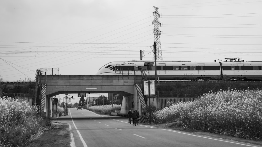 une photo en noir et blanc d’un train traversant un pont