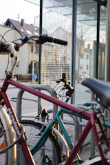 A bicycle parked near a city bus stop with people boarding.