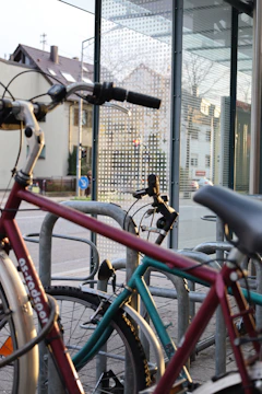 A bicycle parked near a city bus stop with people boarding.