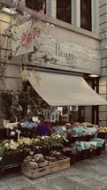 A cheerful delivery person handing a bouquet of fresh flowers to a smiling customer at a Parisian doorstep.