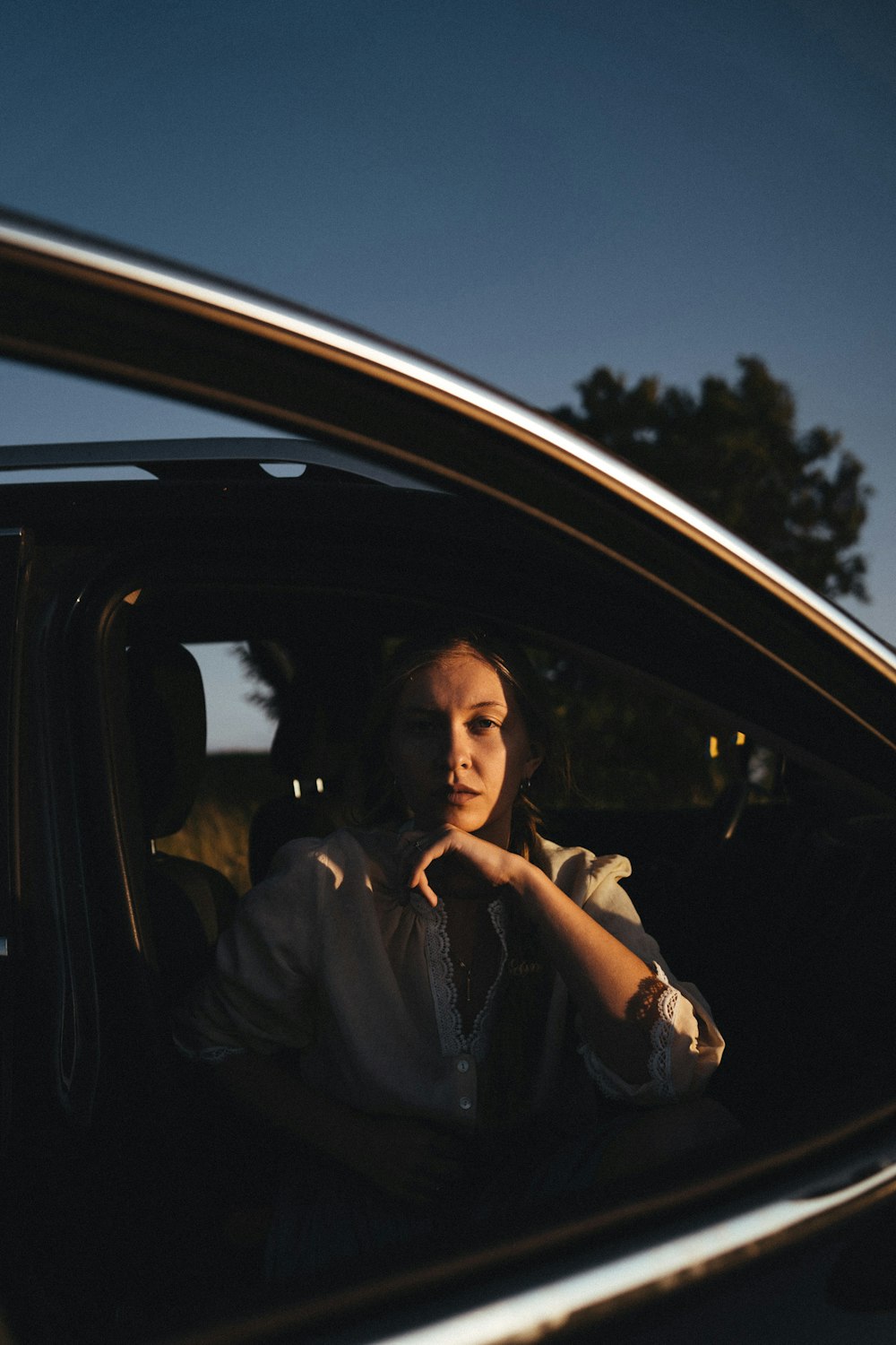 a woman sitting in a car looking out the window