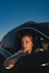 a woman sitting in a car looking out the window
