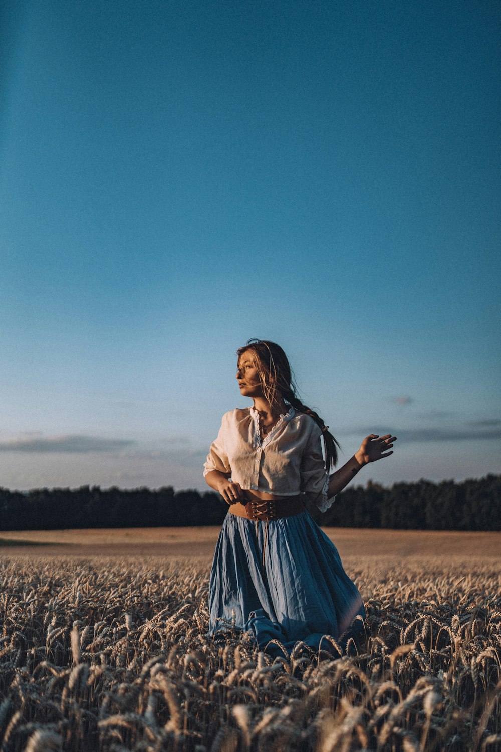 a woman in a blue dress standing in a field