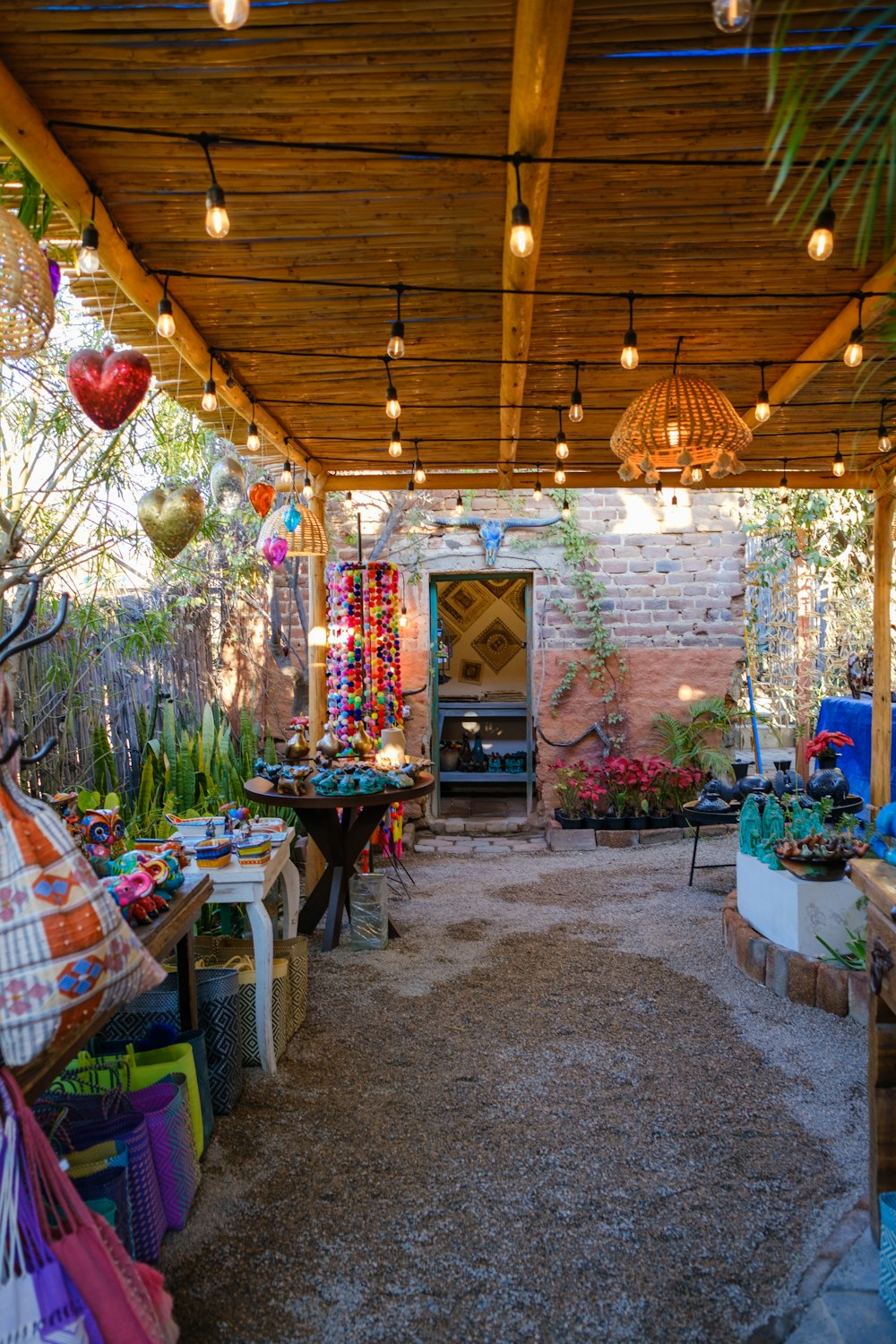 a patio covered in lots of plants and lights