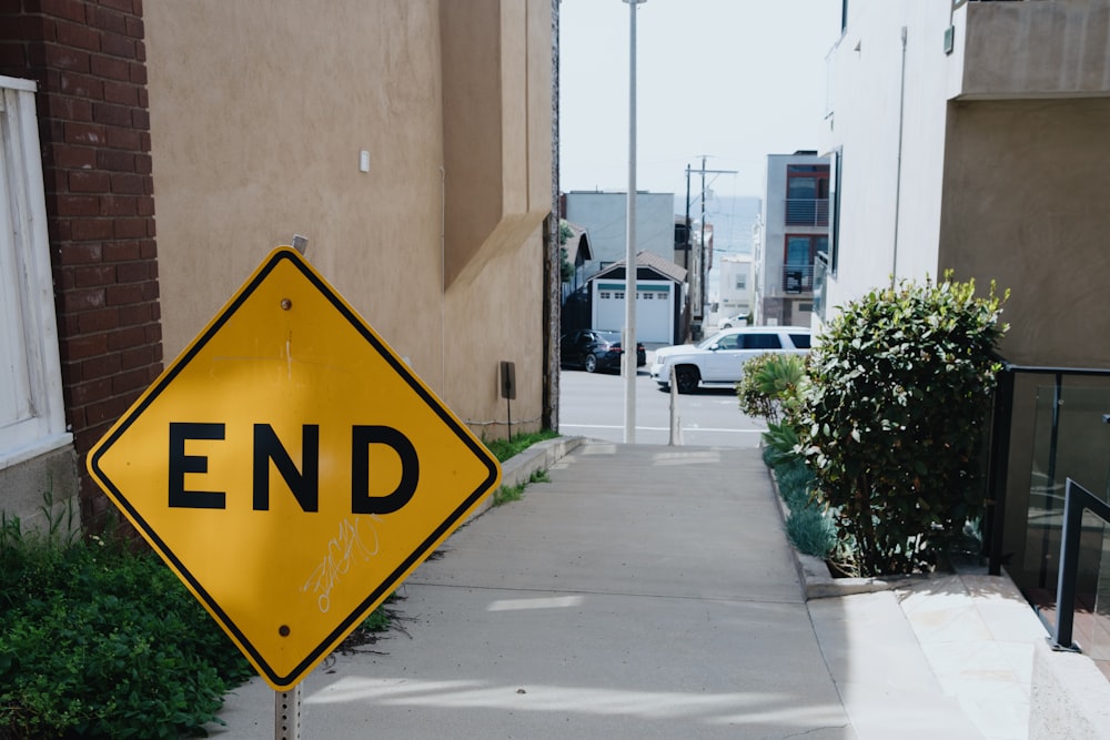 a yellow end sign sitting on the side of a road