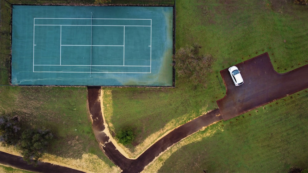 an aerial view of a tennis court and a car