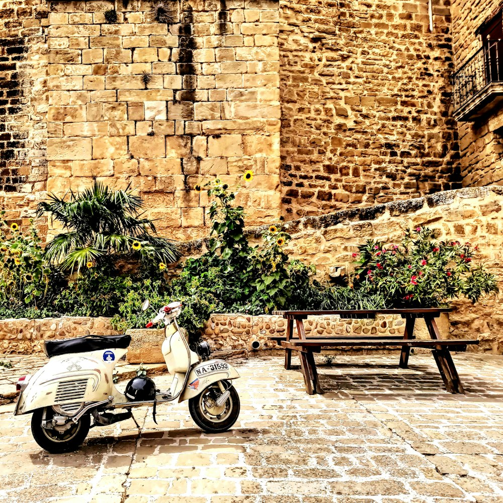 a scooter parked in front of a stone building