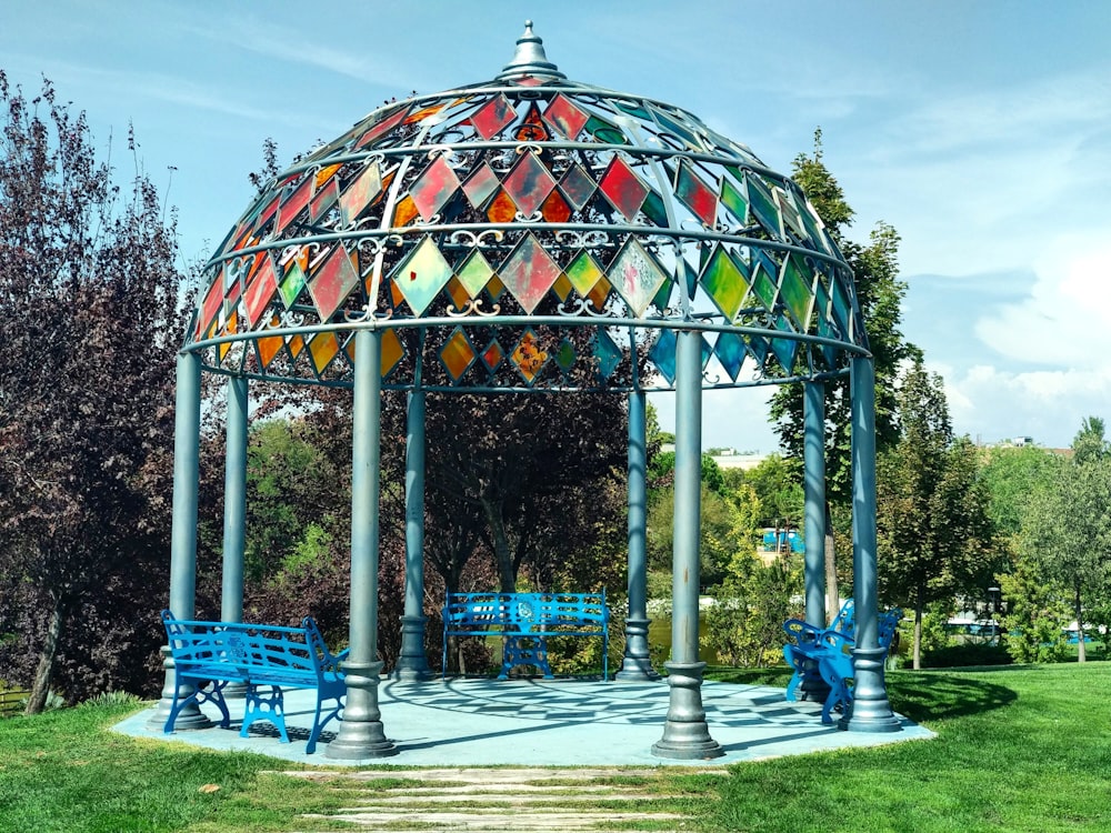 a colorful gazebo in a park with benches