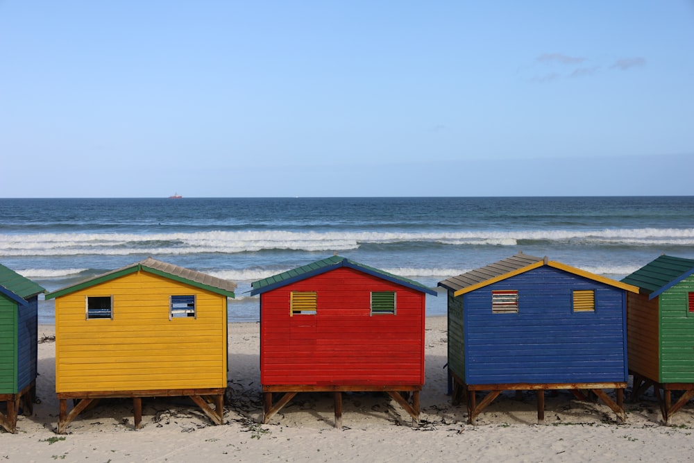 a row of colorful beach huts sitting on top of a sandy beach