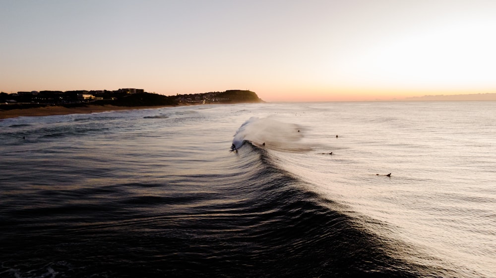 a person riding a wave on top of a surfboard