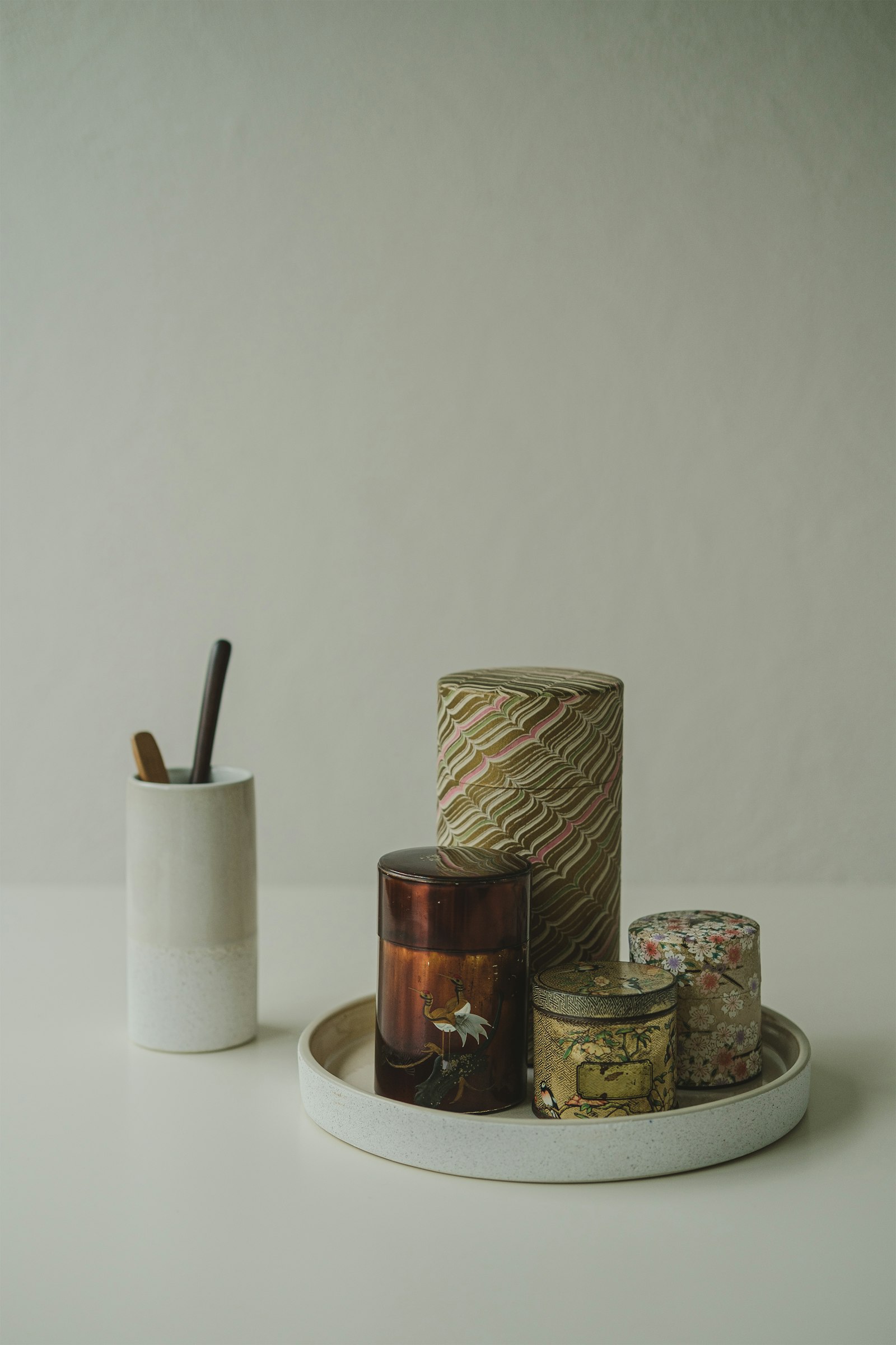 Des boîtes à thé cylindriques en métal et en papier, côte à côte