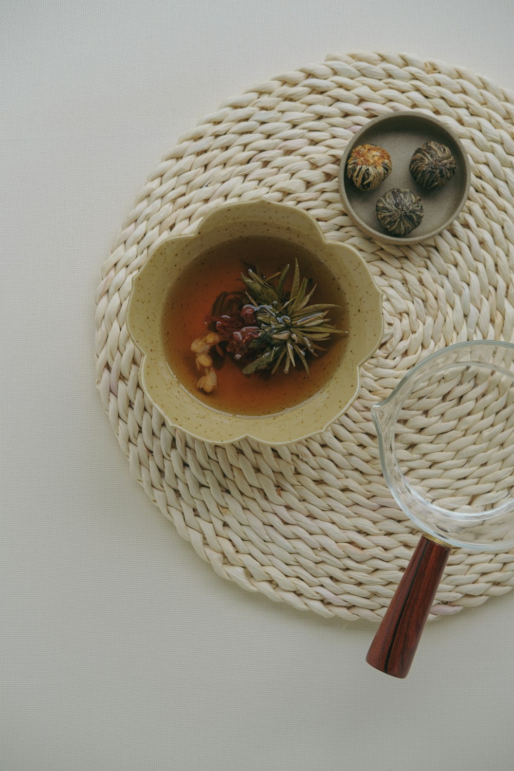 a bowl of soup on a woven place mat with a magnifying glass