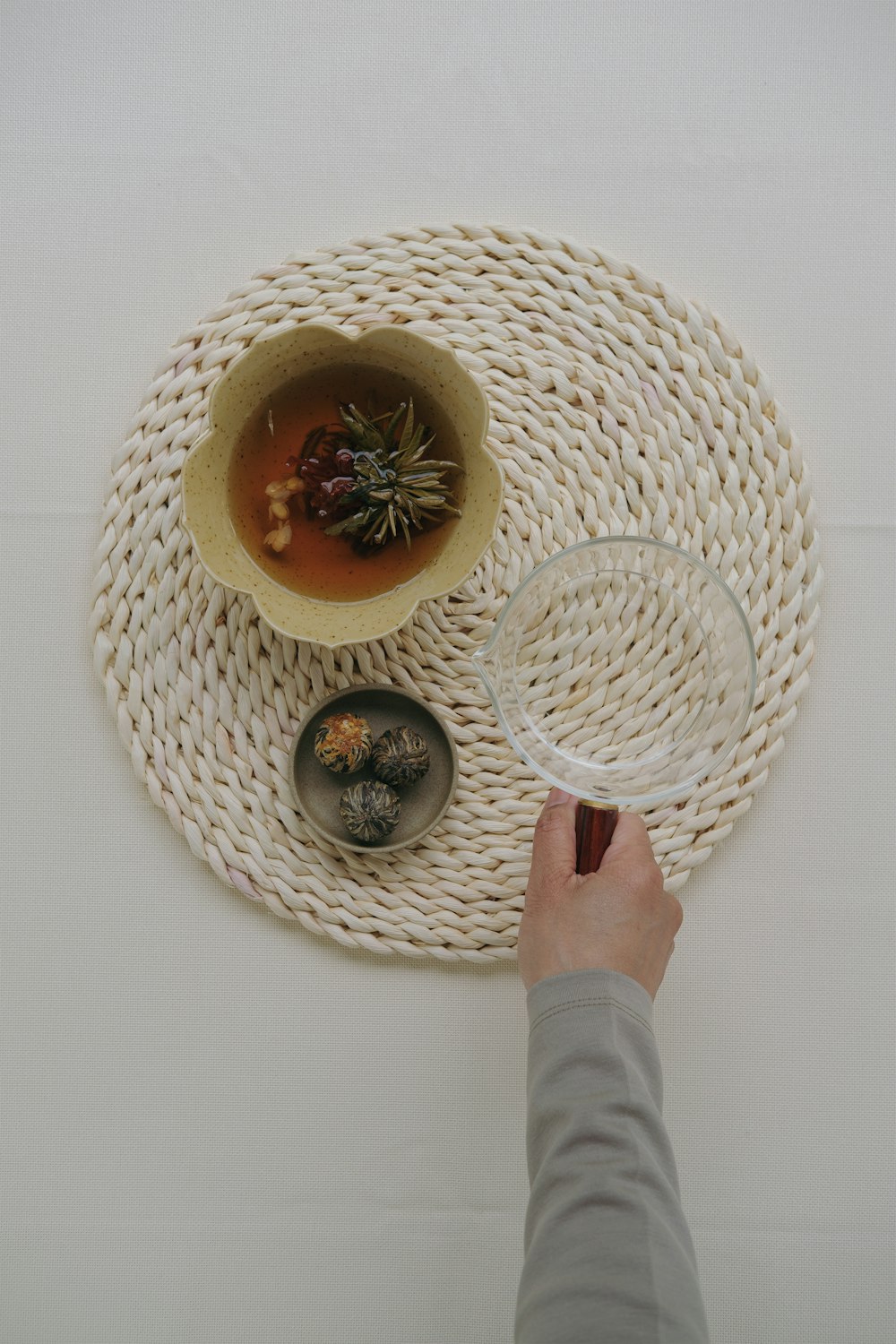 a person holding a wine glass in front of a bowl of soup