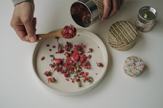 a person scooping rose petals out of a plate