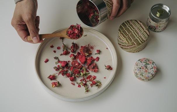 a person scooping rose petals out of a plate