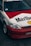 A customized car features a distinctive red and white paint job with large Marlboro and Shell logos. The car is equipped with aftermarket components, including sporty rims and a front bumper. The windshield displays a 'Streetweapon' decal, and there is evident branding inside the car on the seats.