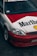 A customized car features a distinctive red and white paint job with large Marlboro and Shell logos. The car is equipped with aftermarket components, including sporty rims and a front bumper. The windshield displays a 'Streetweapon' decal, and there is evident branding inside the car on the seats.