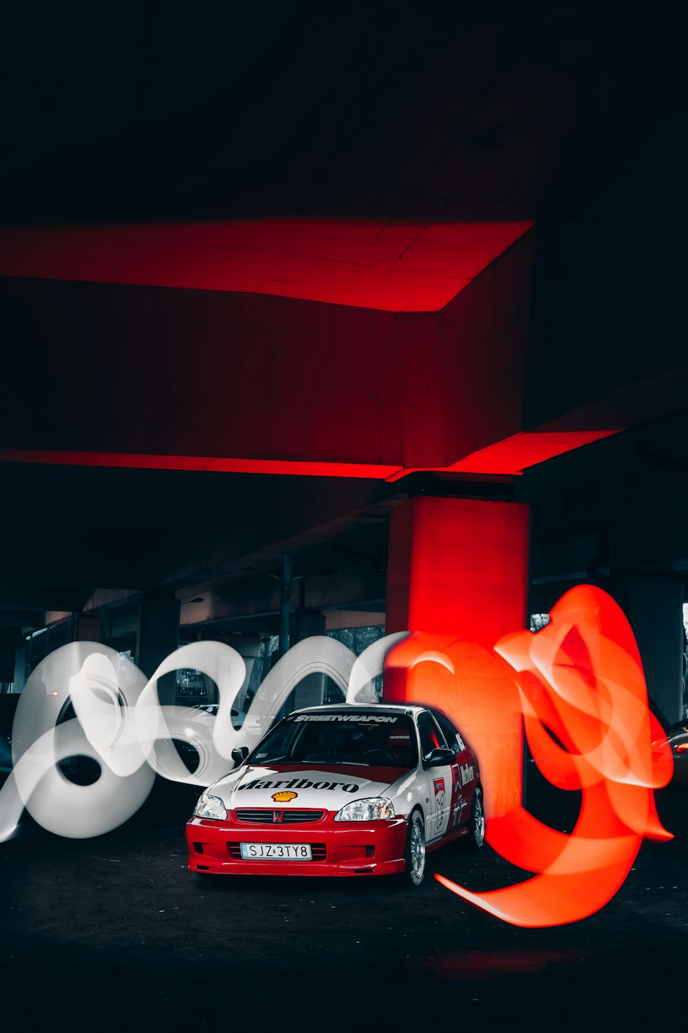 a car parked in a parking garage next to a red light