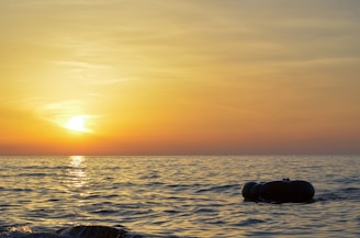 A warm sunset over the outback with a woman holding a floatie, smiling softly.