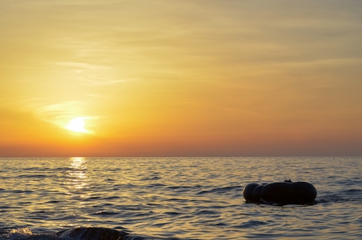 A warm sunset over the outback with a woman holding a floatie, smiling softly.