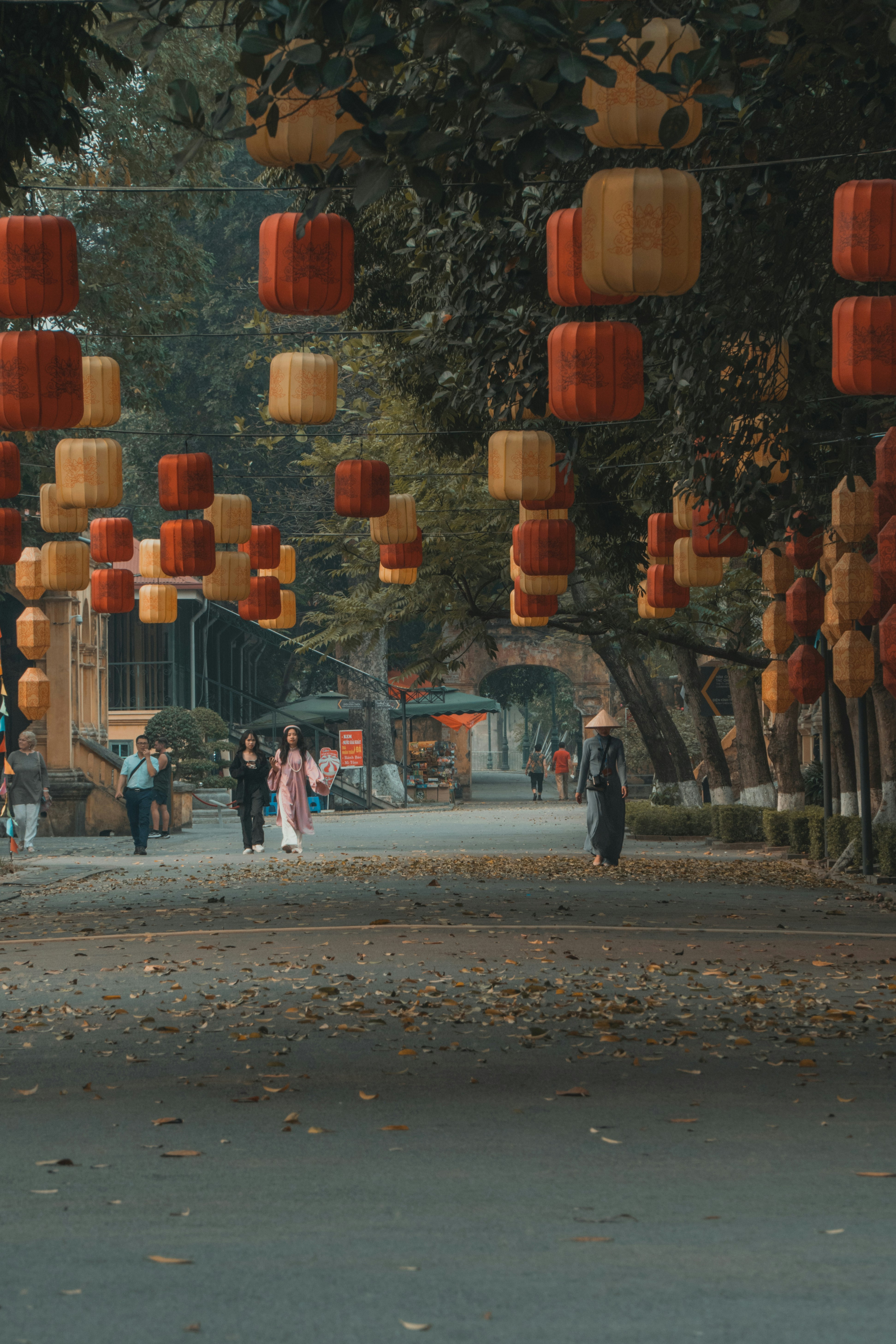 Un groupe de personnes marchant dans une rue sous des lanternes orange