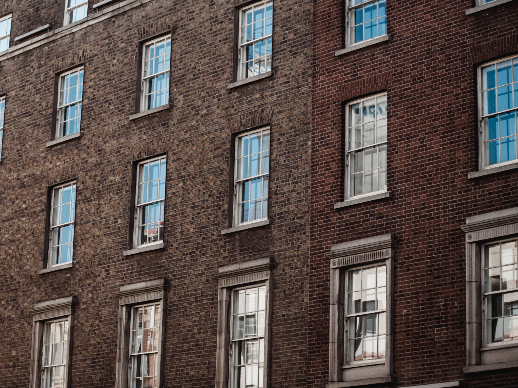 Vintage brick apartment building facade with sash windows