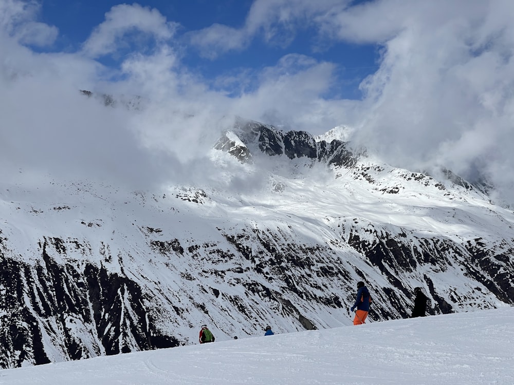 a group of people standing on top of a snow covered slope