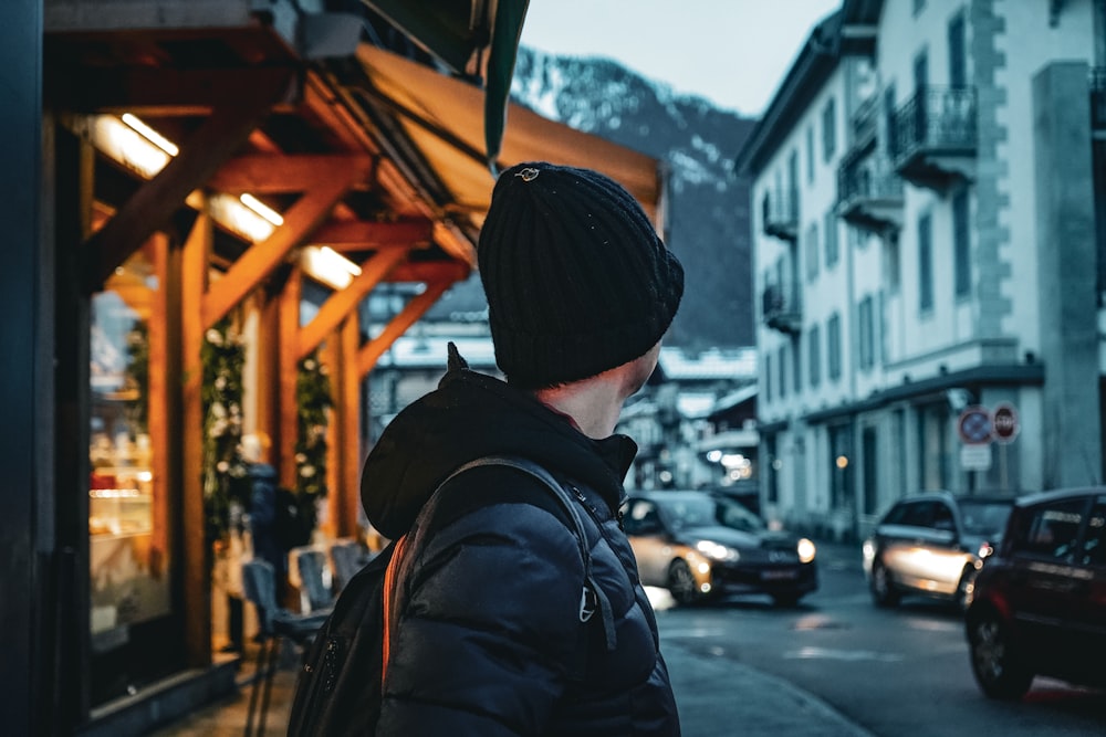 a man standing on a street corner in front of a building