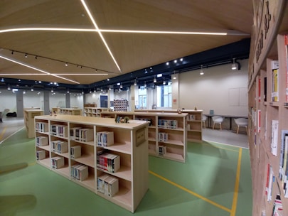 A modern school library with Islamic art decorations and children reading books quietly.