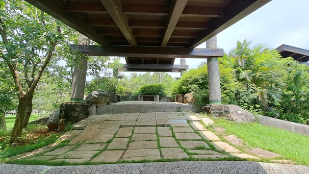 Outdoor pathway paved with smooth granite cubes surrounded by greenery.