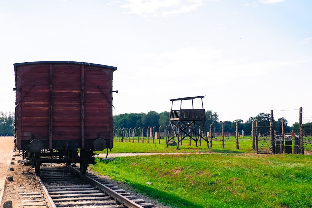 a train car sitting on the tracks in a field