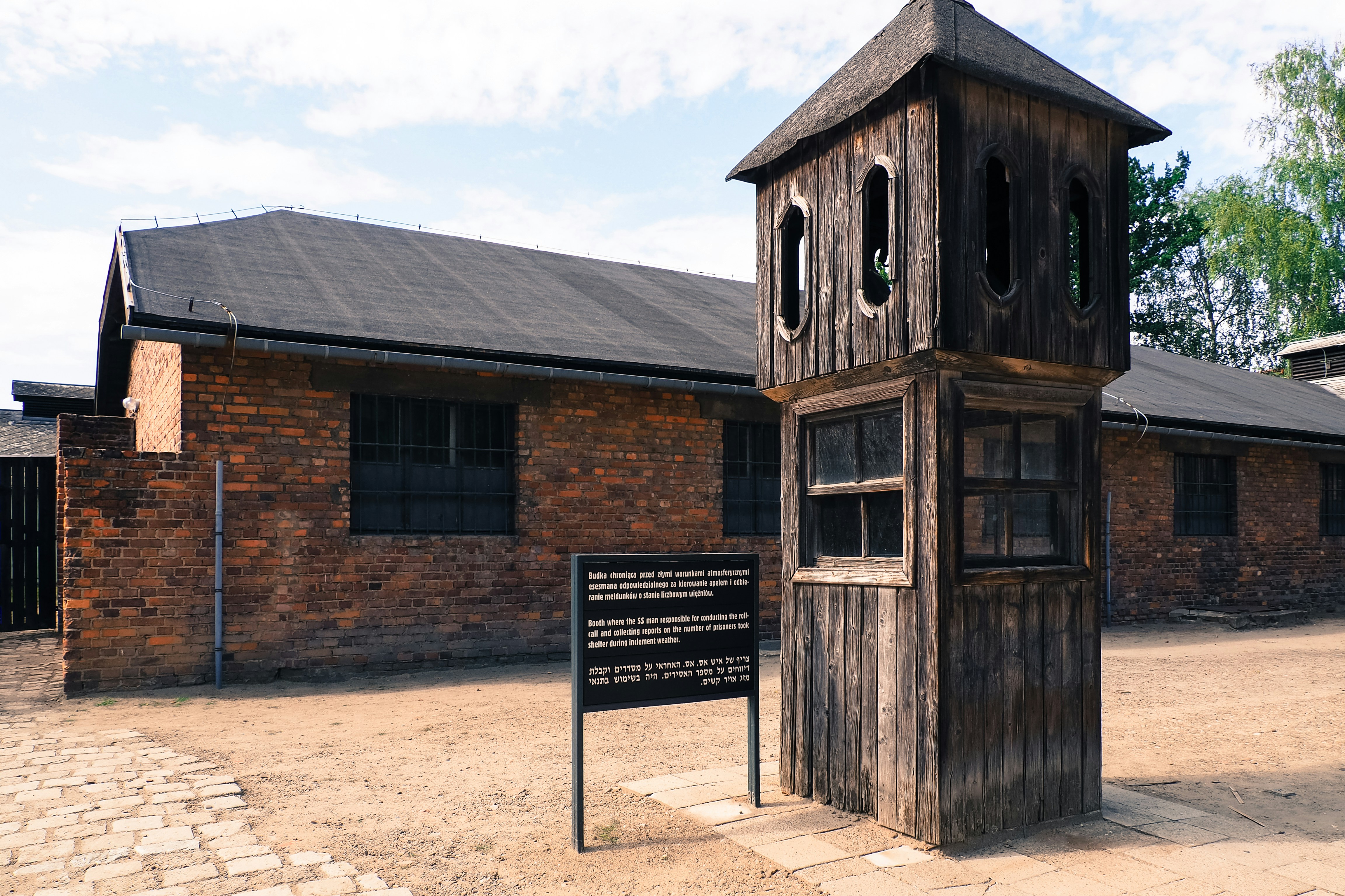 a tall wooden clock tower sitting next to a brick building