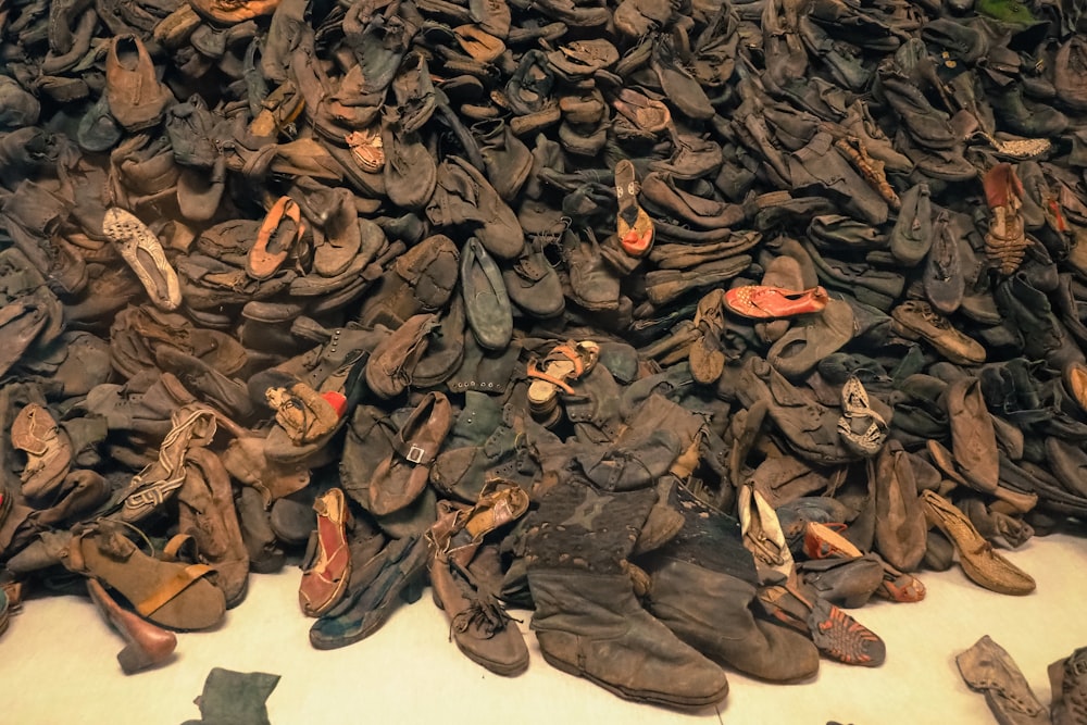 a pile of old shoes sitting on top of a white floor