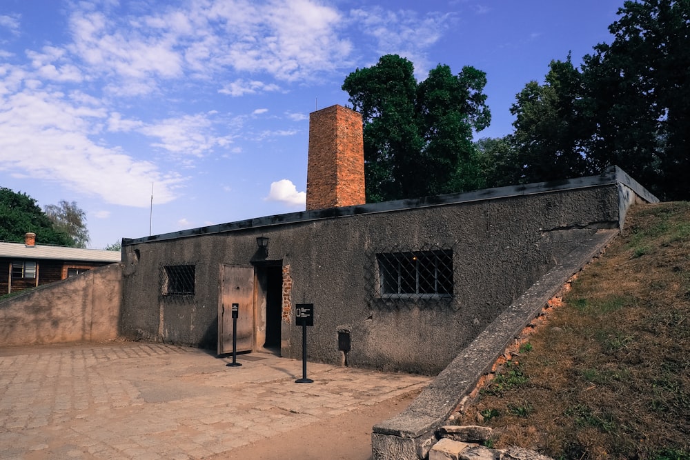 a building with a brick chimney next to a stone wall