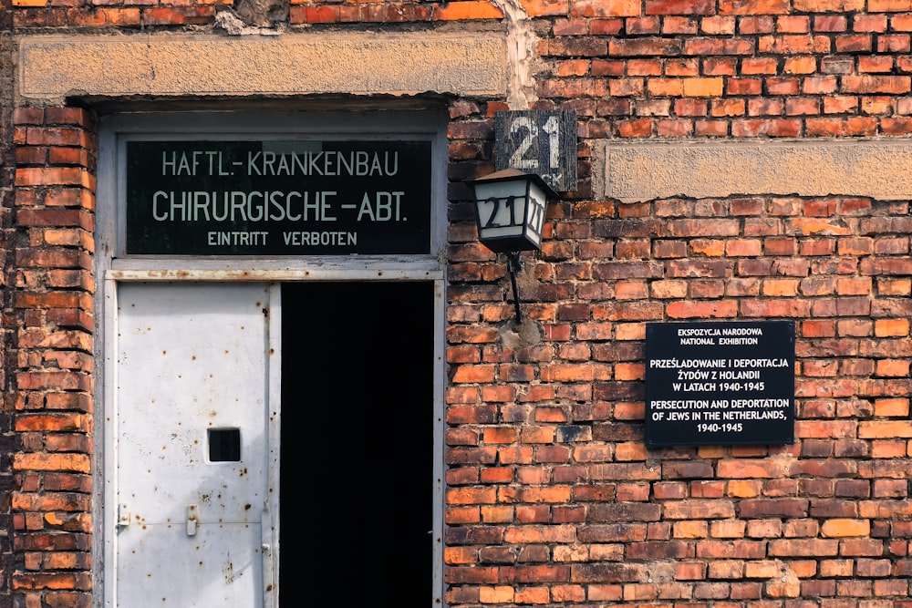 a brick building with a door and a sign on it