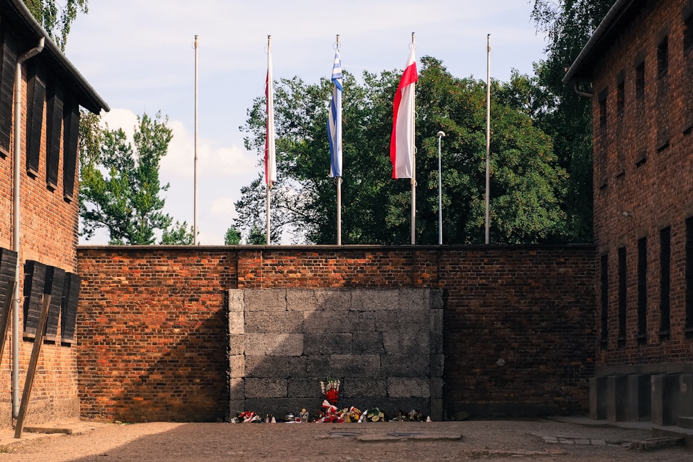 a brick wall with a bunch of flags on top of it