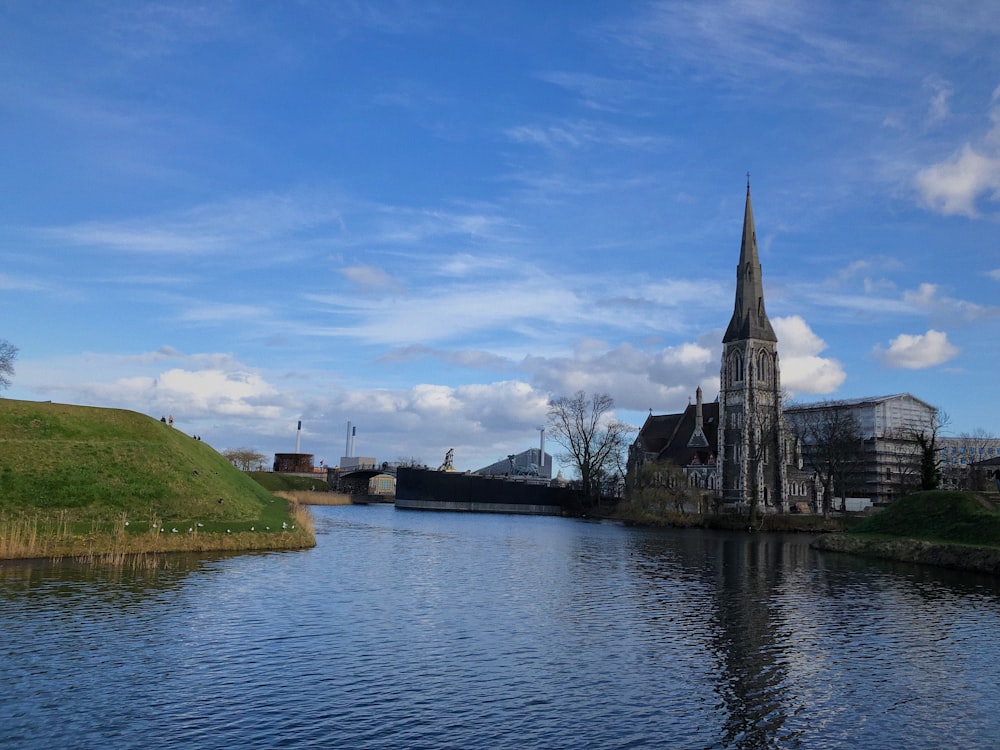 ein Fluss mit einem Kirchturm im Hintergrund