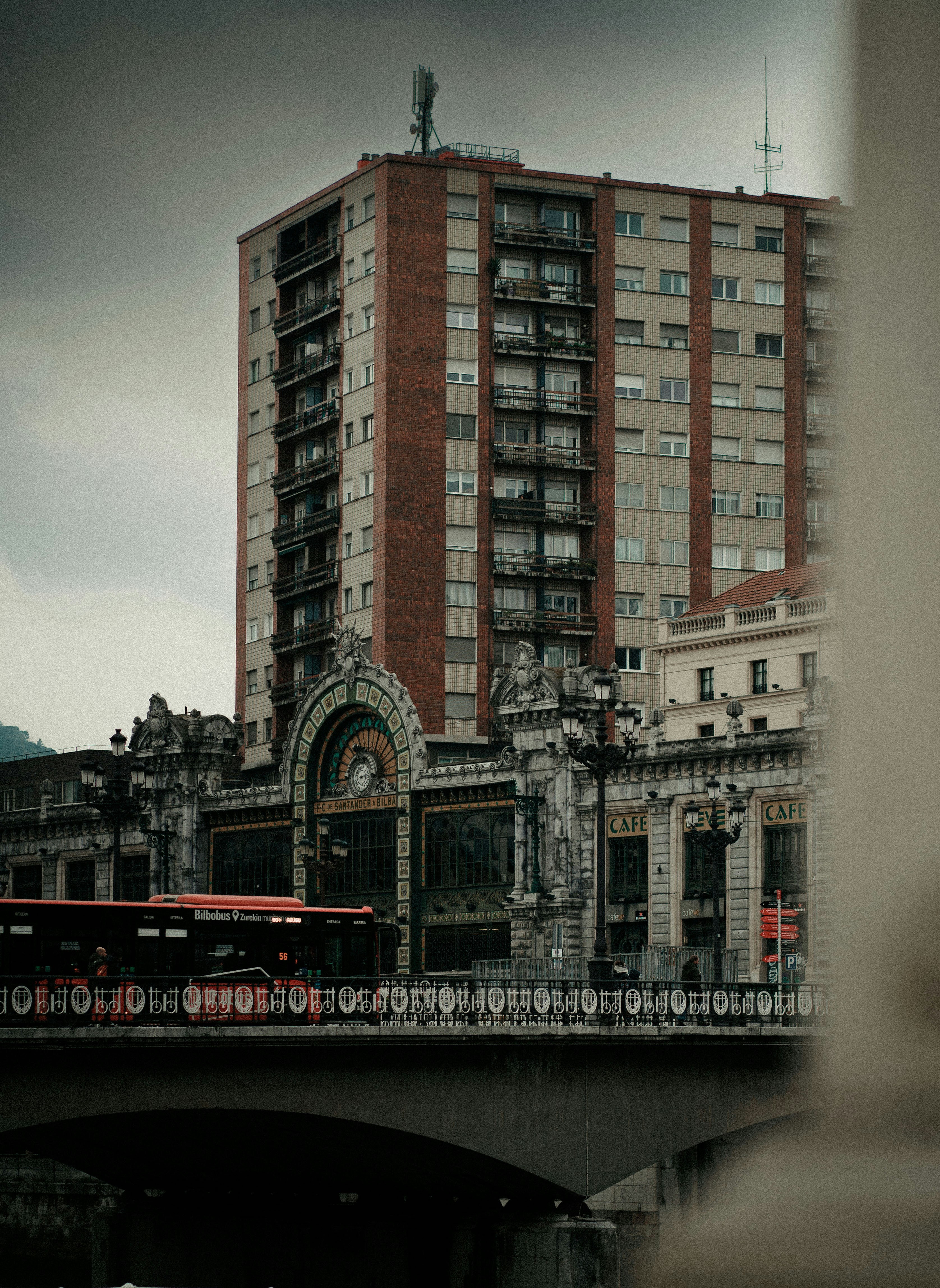 a train traveling over a bridge in front of a tall building