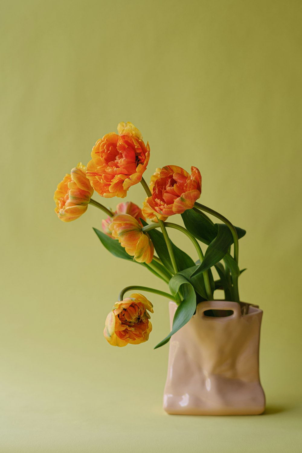 a vase filled with orange flowers on top of a table