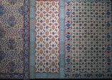 The image features a series of intricately designed tiles with intricate floral and geometric patterns. The tiles display a variety of colors, predominantly featuring blues, whites, reds, and greens with elaborate motifs and symmetrical designs.